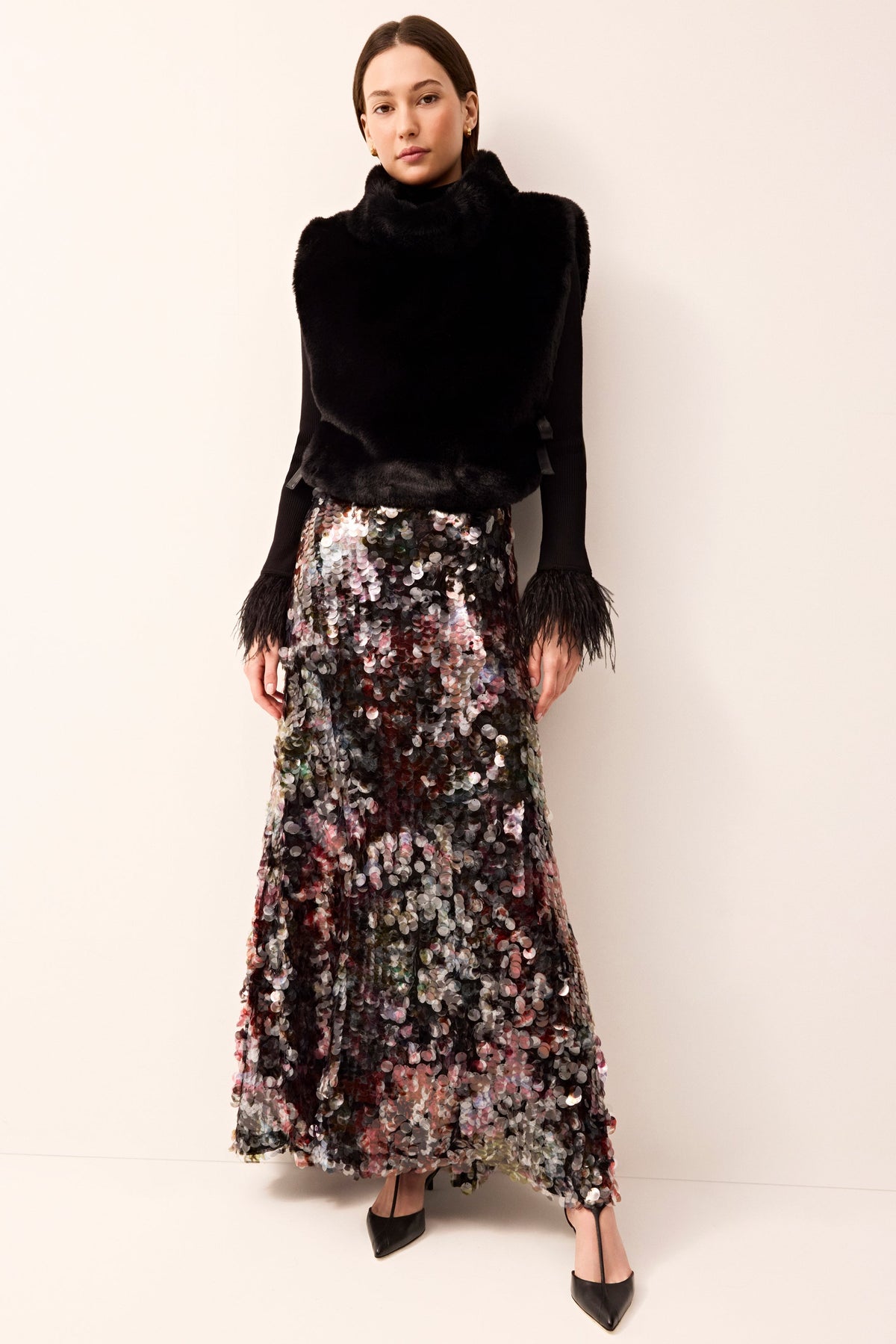 Cozy black faux-fur vest with a turtleneck and side ties for a customizable fit.