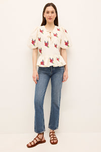White short sleeve top with vibrant tropical bird motifs and a bow neckline 