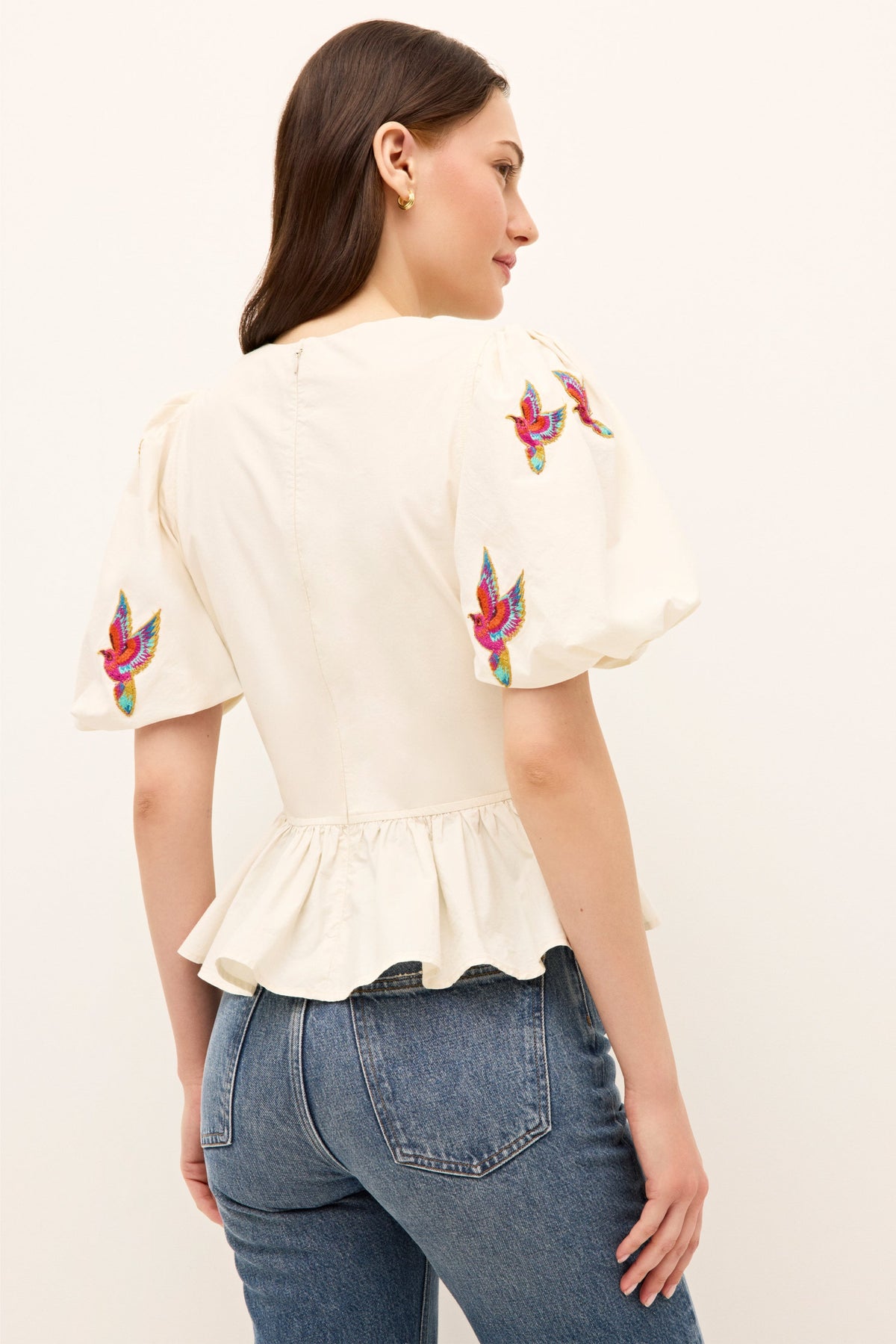 Whimsical ivory blouse with cinched waist, bird embroidery, and feminine silhouette 