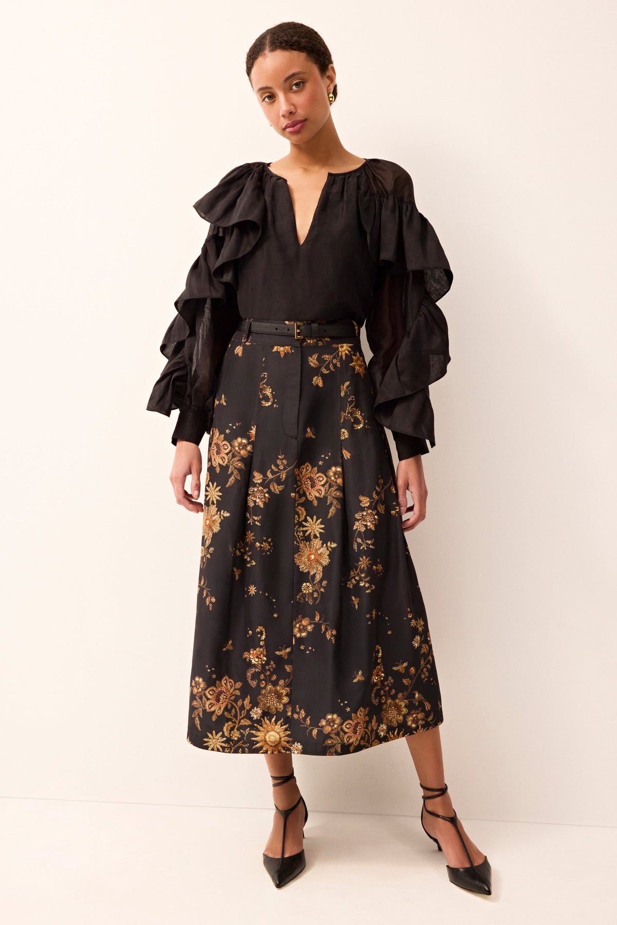 Black and gold printed midi skirt with a tailored fit and structured design.