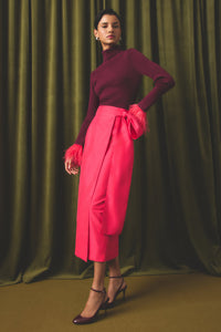 Straight bright pink wrap skirt with a dramatic bow detail at the waistline.