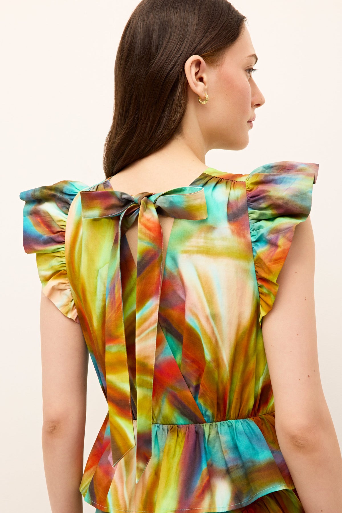 Sleeveless dress featuring a rainbow watercolor print and voluminous ruffle layers 