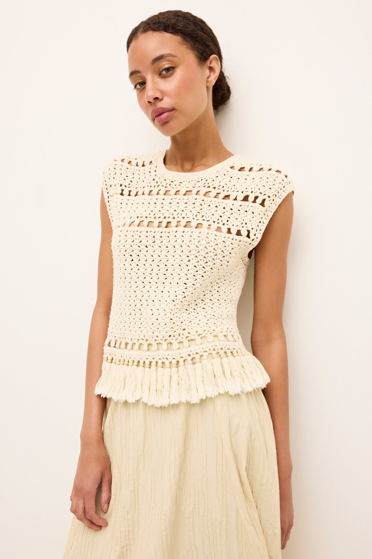 Textured ivory tank with intricate crochet pattern and tassel trim