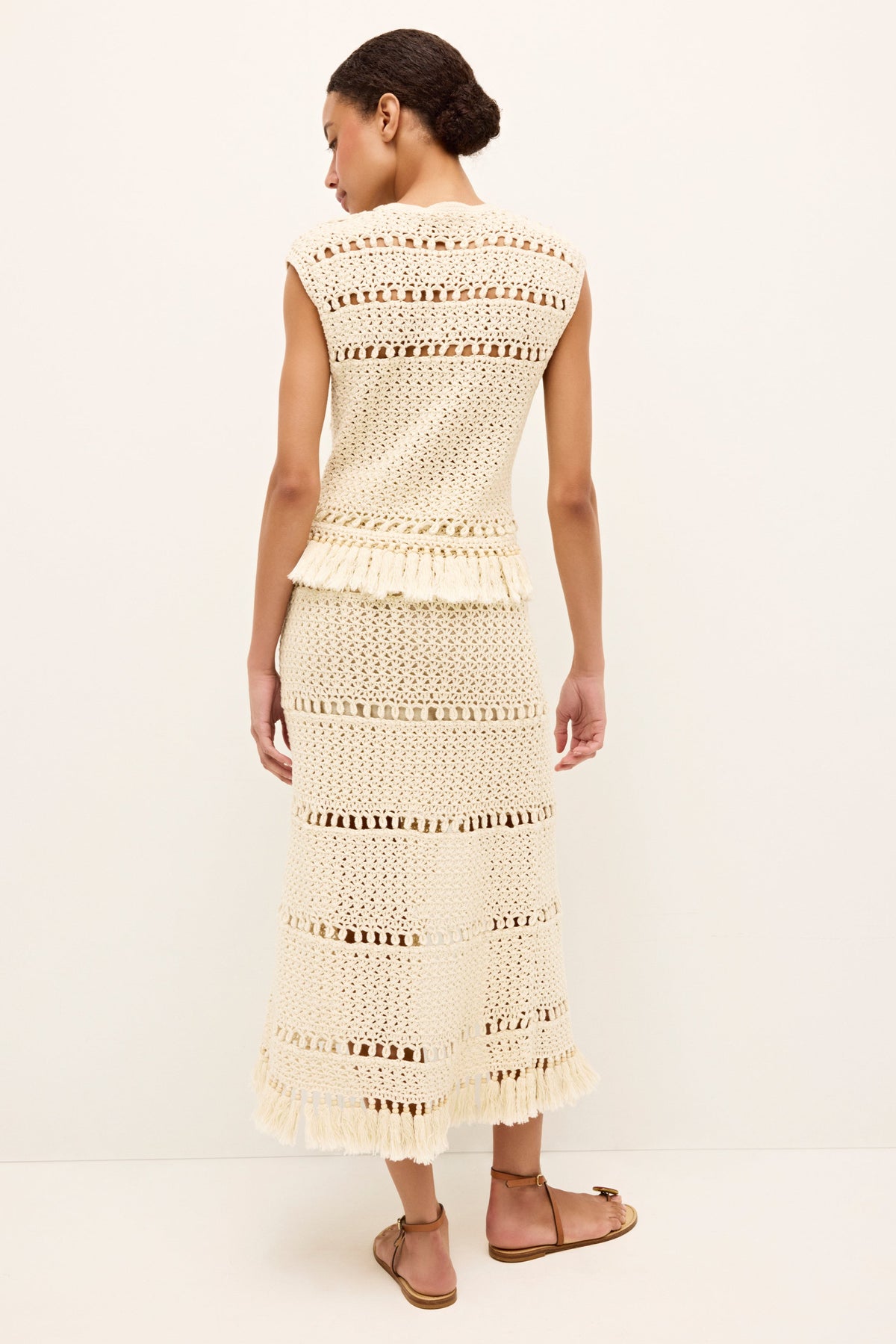 Ivory sleeveless top with handcrafted crocheted design and ornamental hem