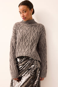 Gray cable knit sweater with long sleeves and mock neck and has silver metallic shimmer throughout 