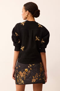 Black puff-sleeve sweater featuring allover beaded bee embroidery.