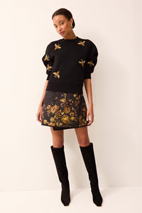 Half-sleeve black knit top adorned with embroidered and beaded bee motifs.