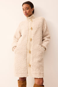 Cream sherpa jacket featuring a full front closure with wooden buttons.
