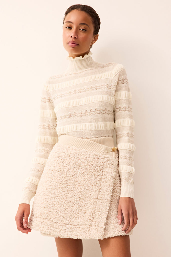 Sherpa mini wrap skirt featuring a buttoned waist closure.