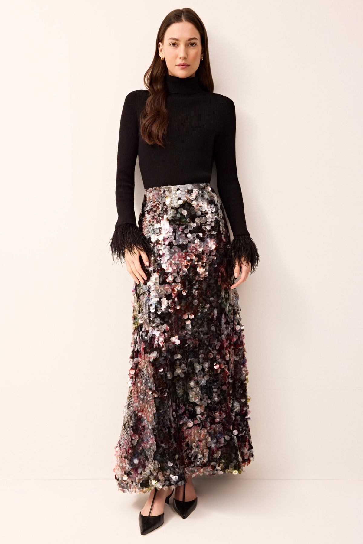 Elegant black long-sleeve knit turtleneck featuring fitted silhouette and feather-trimmed sleeve hems.