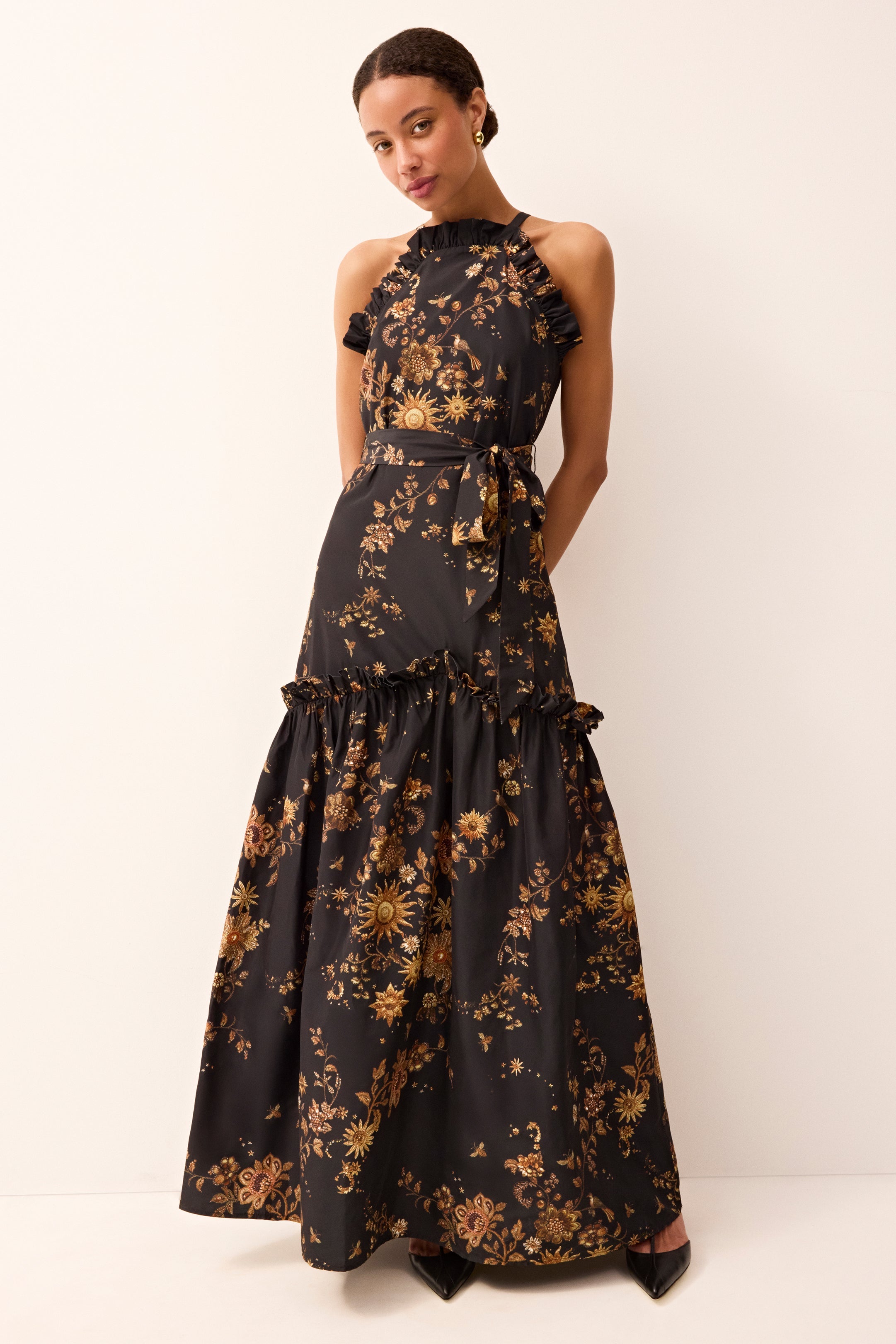 Long formal dress with halter top ruffle on the skirt and an all over black and gold floral design 