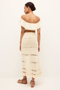 Knit look cream skirt with decorative open loops, center front slit, and fringe trim 