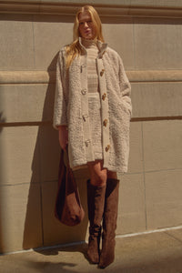 Textured beige coat with buttons down the front 