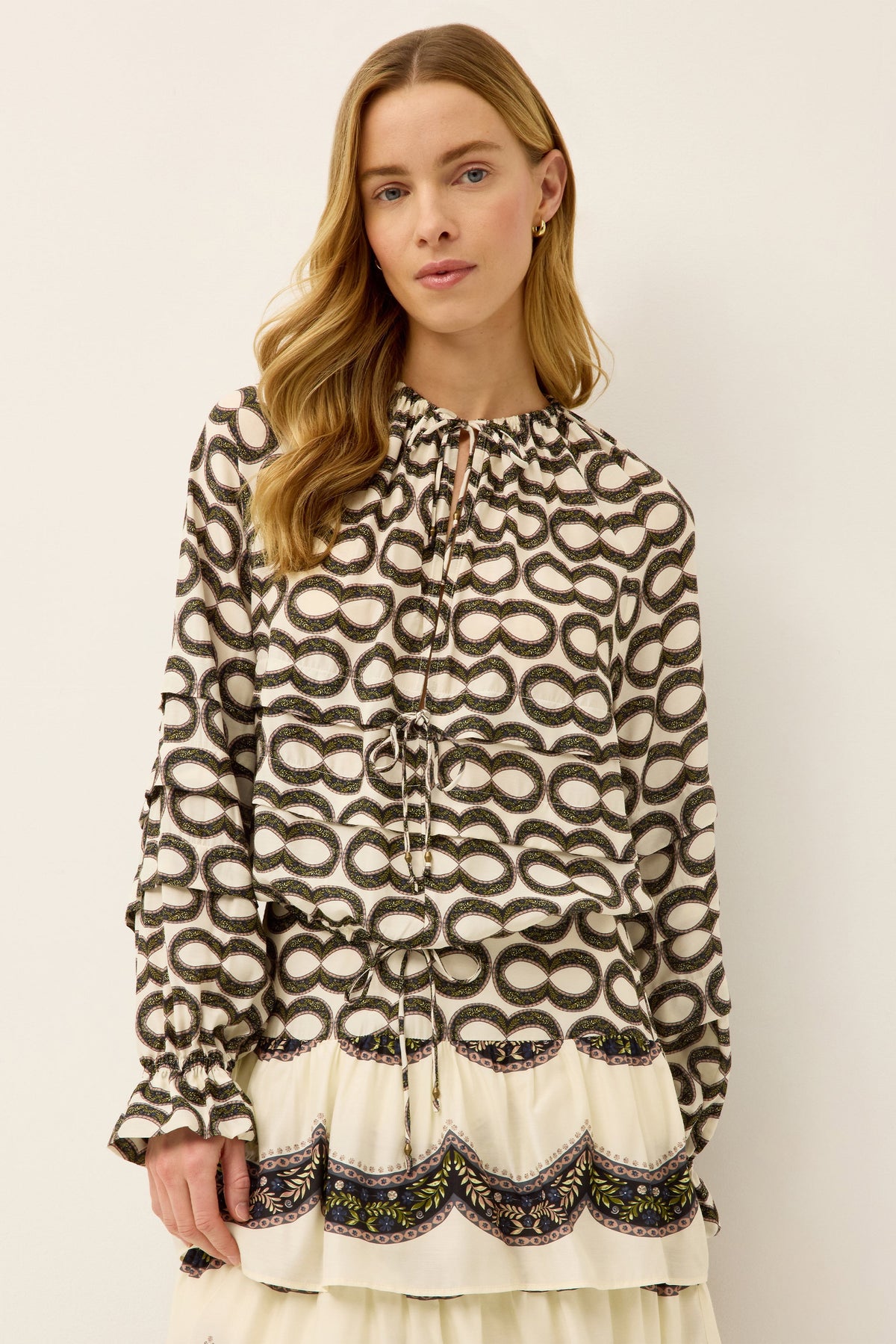 Front view of Umi Blouse in Infinity showing printed peasant blouse with plunging neckline, front ties, elastic cuffs, cropped fit