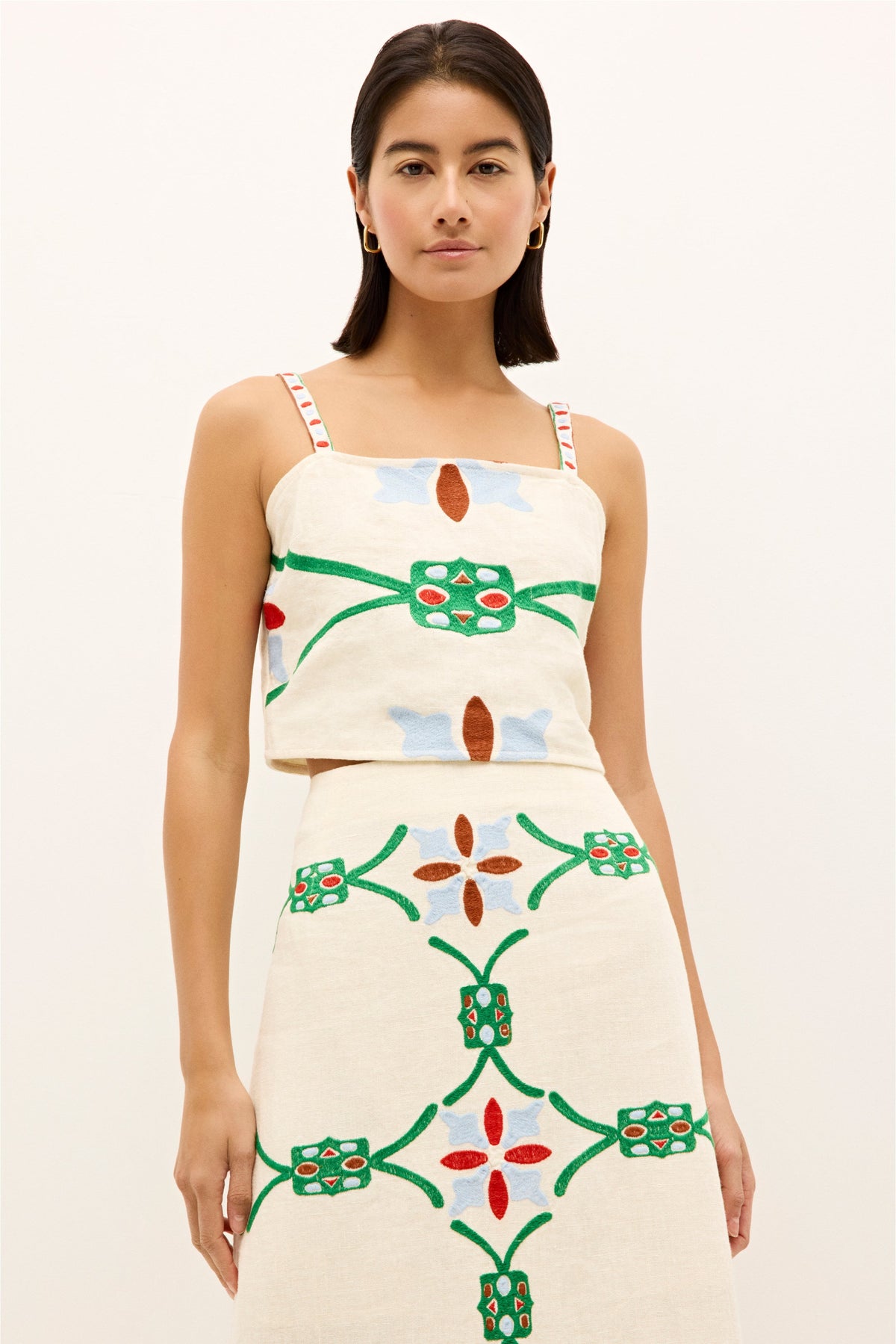 Sleeveless square neck top with green, red, and blue stitched motifs 
