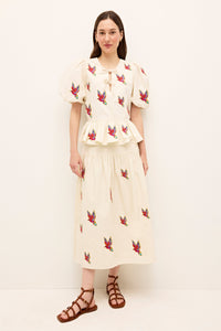 White A-line skirt with colorful embroidered bird motifs throughout 