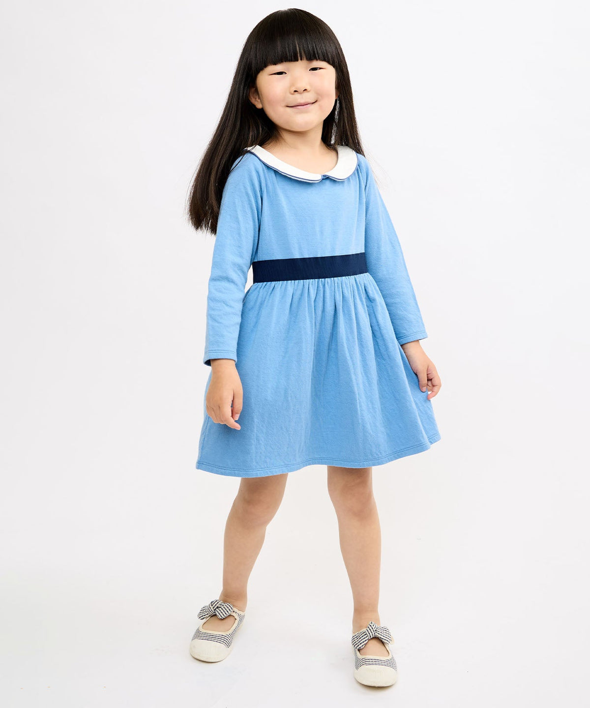Front view of Marie Clare Dress showcasing blue long-sleeve jersey with white Peter Pan collar and navy waist band against white