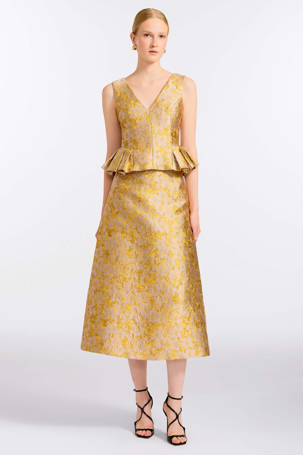 Front view of Jasminium Gold Top showcasing its gold floral pattern and peplum silhouette on a model against a light background