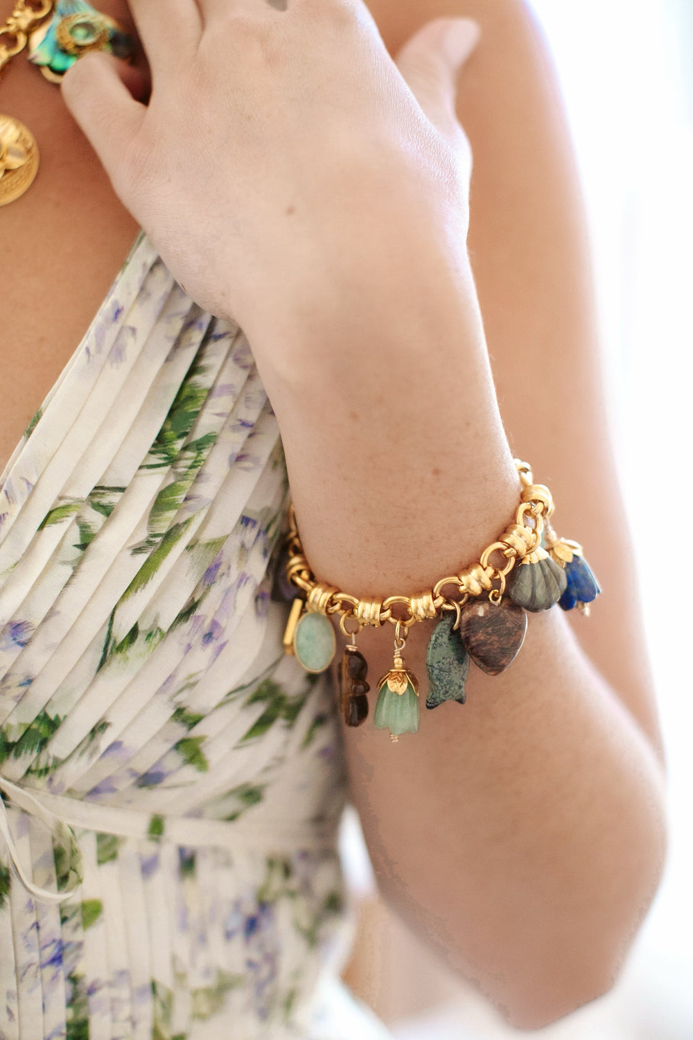 Close-up of Mermaid Parade Bracelet on wrist showcasing 24K gold-plated chunky link chain with green and blue semi-precious charms