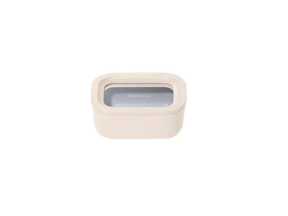 Angled top view of Mini Rectangle Container in cream showcasing clear-window lid with Caraway logo on white background