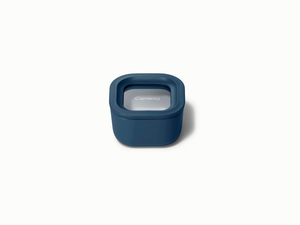 Front view of Mini Square Container in navy showing sealed lid with Caraway logo on white background