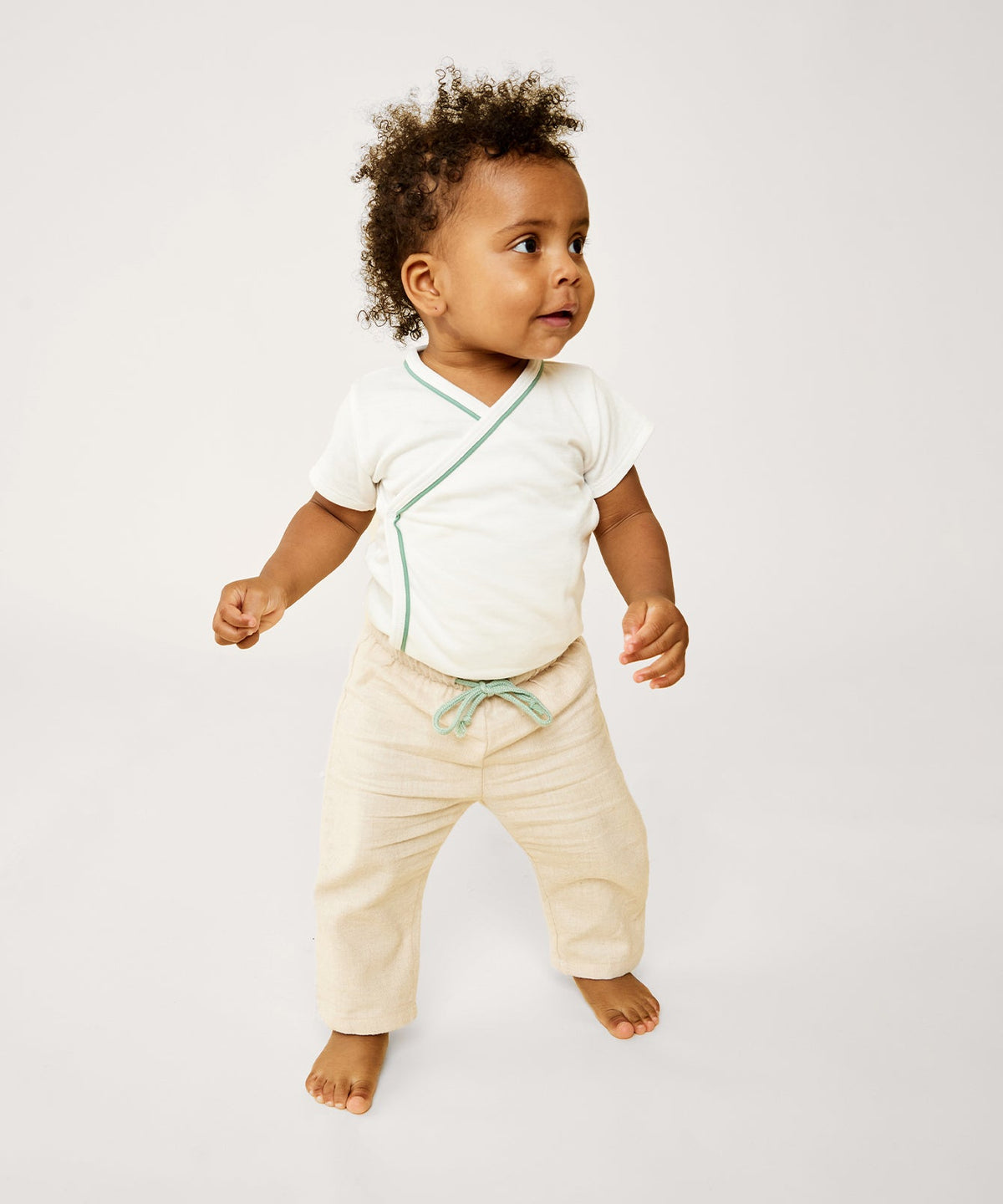 Front view of the oatmeal flannel Bowie Baby Pant on a baby, showcasing the contrast drawcord against a plain light background