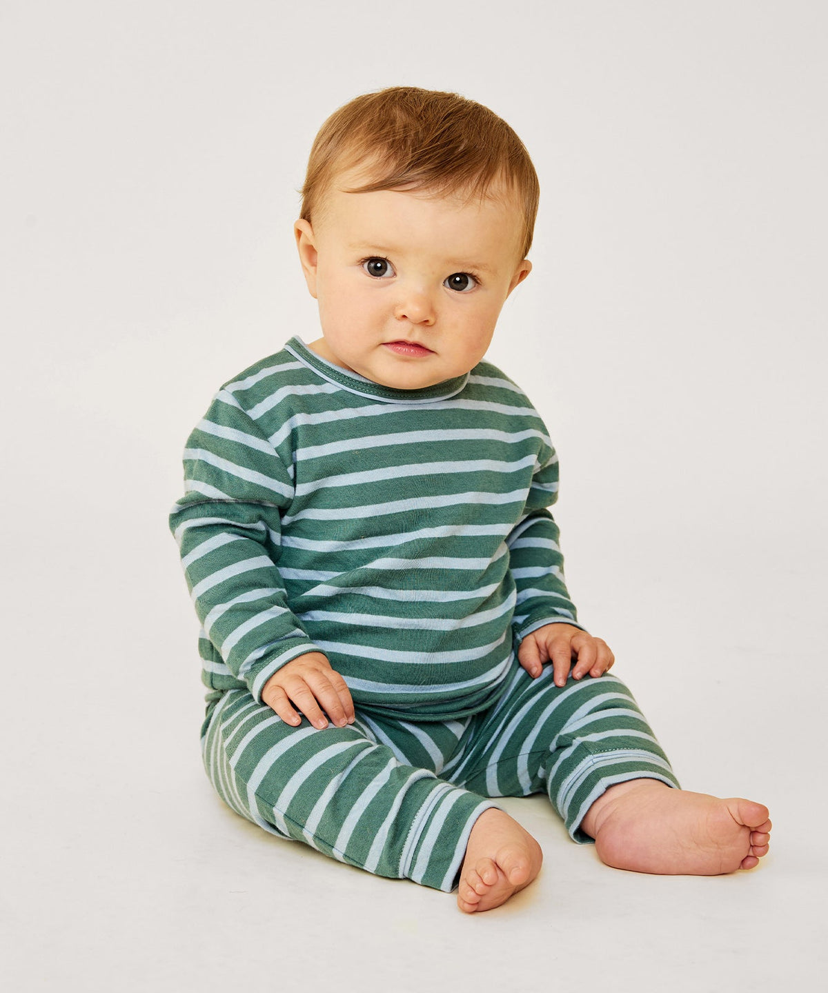 Front view of Edward Baby T-Shirt in Forest Stripe showing long sleeves and contrast piping on seated baby