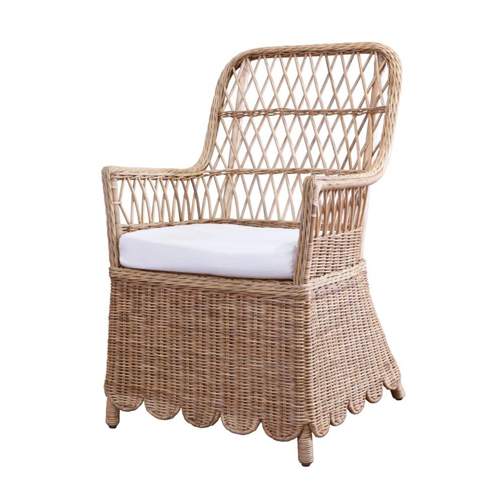 Three-quarter view of Monaco chair showing natural woven rattan, lattice back, scalloped skirt, and white cushion on a white background