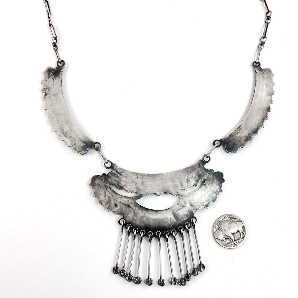 Front view of vintage three panel sterling silver necklace with American turquoise and dangling star studs on white background