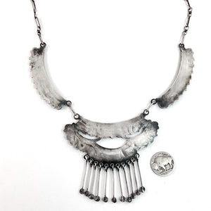 Front view of vintage three panel sterling silver necklace with American turquoise and dangling star studs on white background