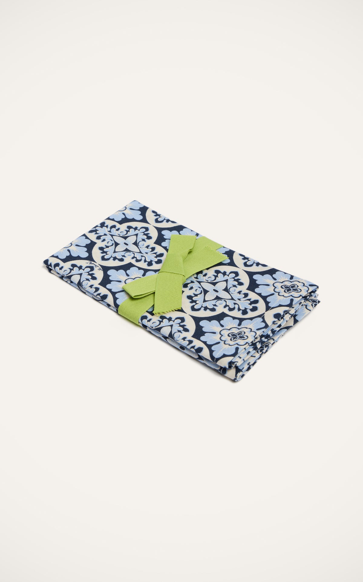 Close-up of Large Napkins in Palazzo Blue, Set of 2 showcasing the Palazzo print and green ribbon on a cream background