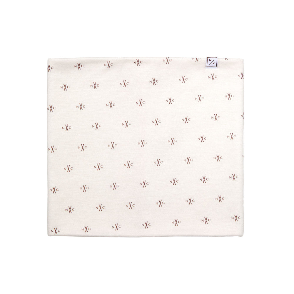 Flat lay of NC Skis fleece-lined neck warmer showing all-over small brown N/C ski logo print on pale pink fabric