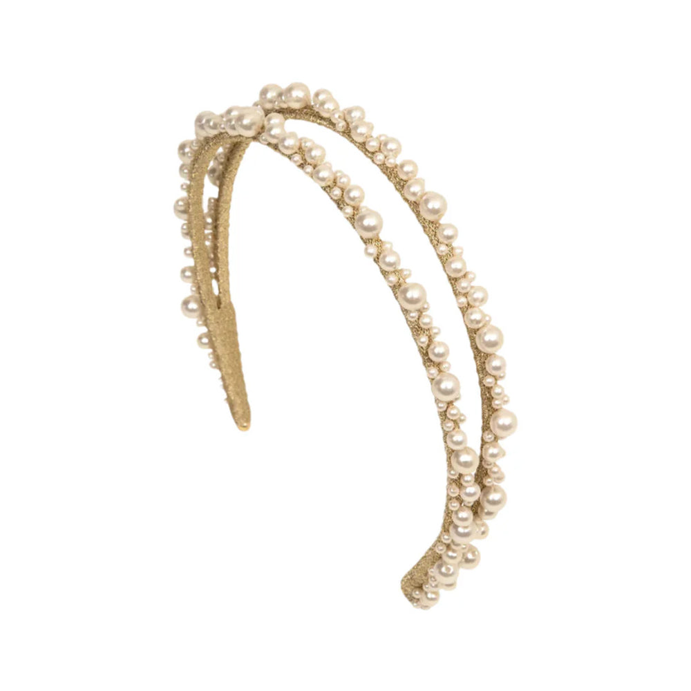 Angled view of Perlita headband in pearl showcasing two slim gold bands decorated with graduated faux pearls on a white background