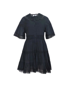 Front view of Newton Dress in Onyx showcasing lace yoke, pintucks, flutter sleeves, and tiered lace hem on white background