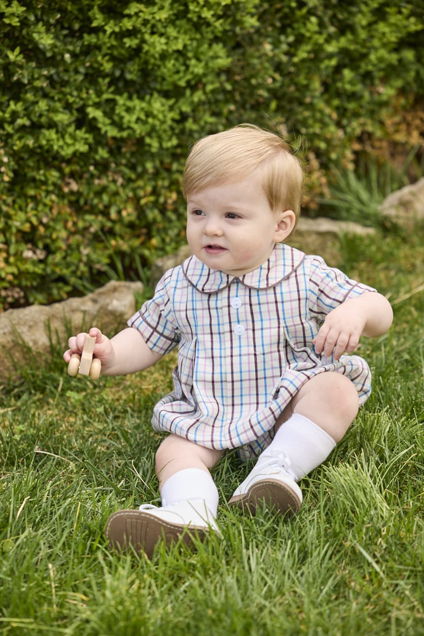 Little English traditional children's clothing.  Short sleeve peter pan bubble in brown, blue, and pink Wilmington Plaid for baby boys with button tabs and corduroy piping.