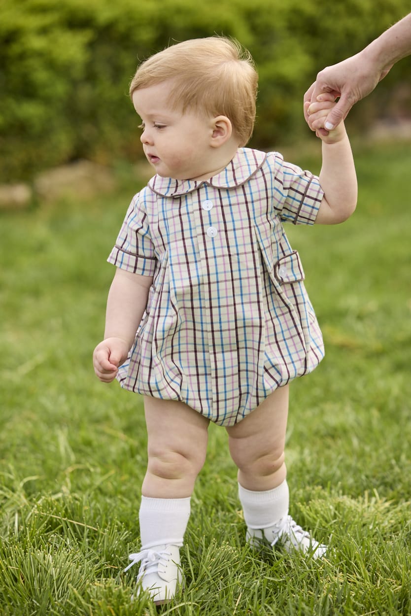 Little English traditional children's clothing.  Short sleeve peter pan bubble in brown, blue, and pink Wilmington Plaid for baby boys with button tabs and corduroy piping.