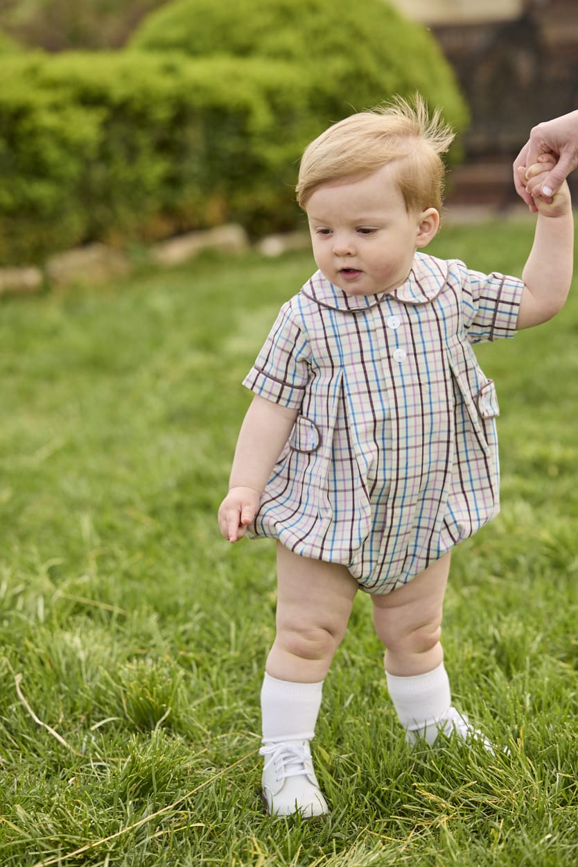 Little English traditional children's clothing.  Short sleeve peter pan bubble in brown, blue, and pink Wilmington Plaid for baby boys with button tabs and corduroy piping.