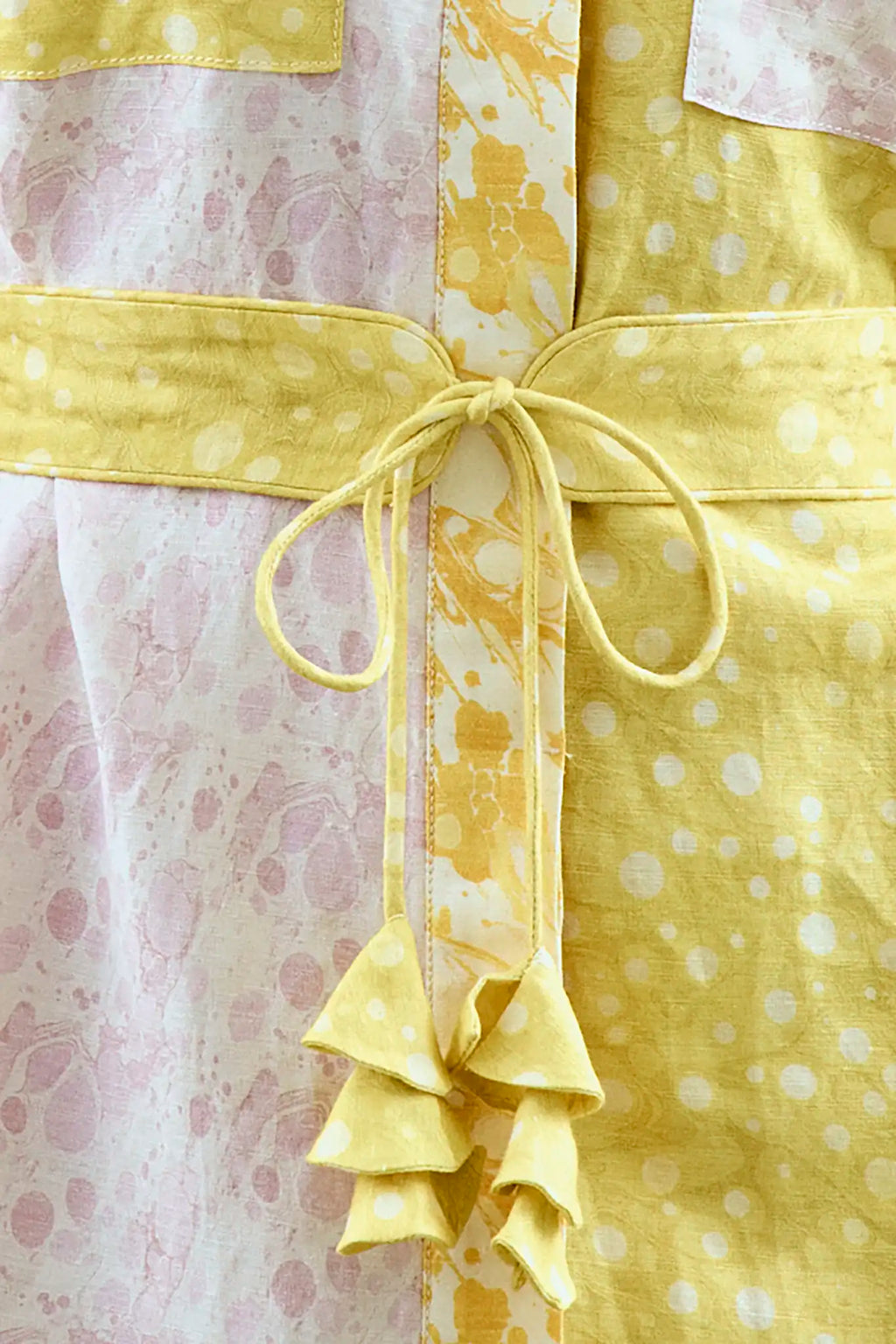 Close up of the Nicole Dress in Marble Mix with self-tie belt and fabric bell ends.