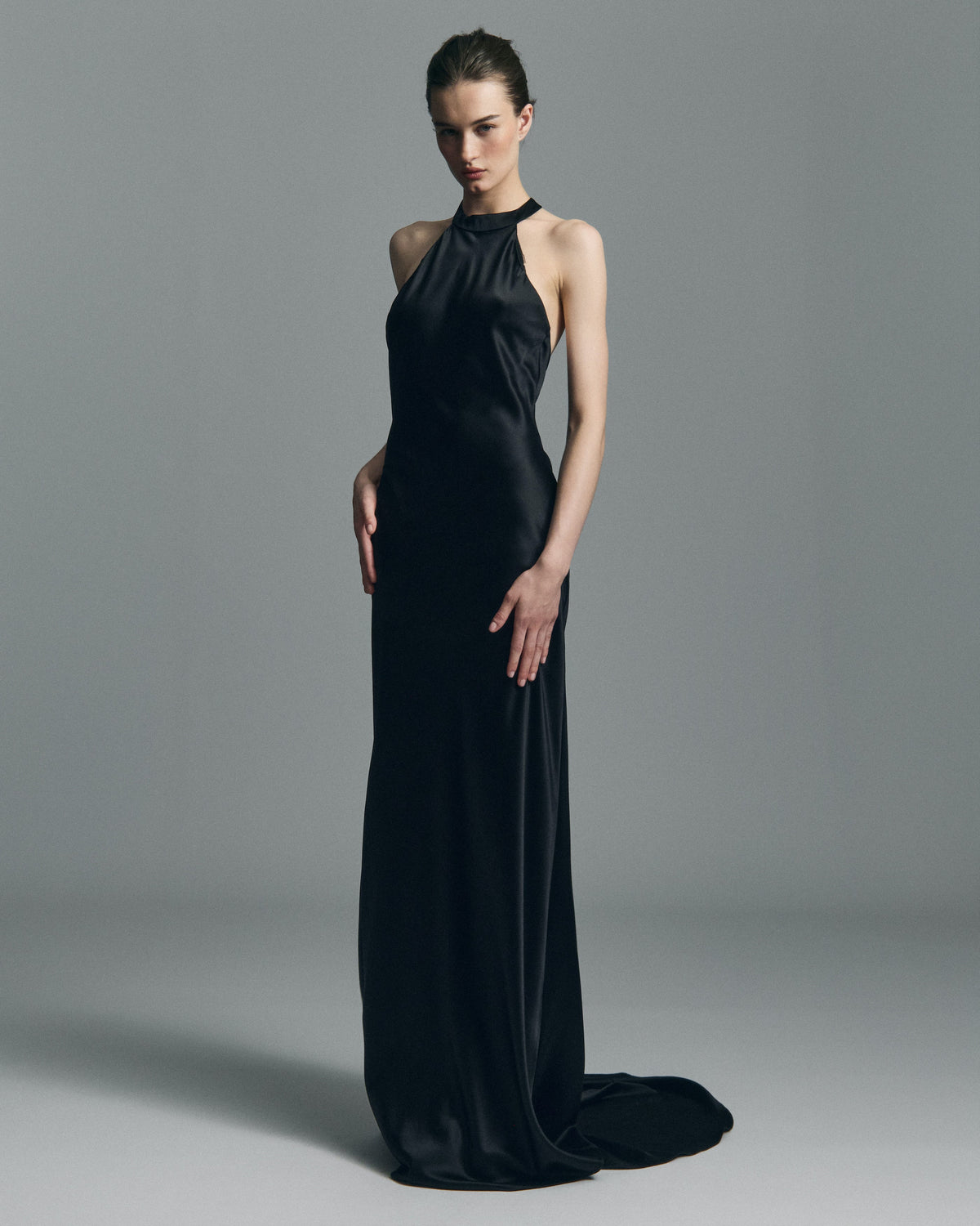 Front view of Nightfall silk maxi dress showcasing halter neck and floor-length drape on gray background