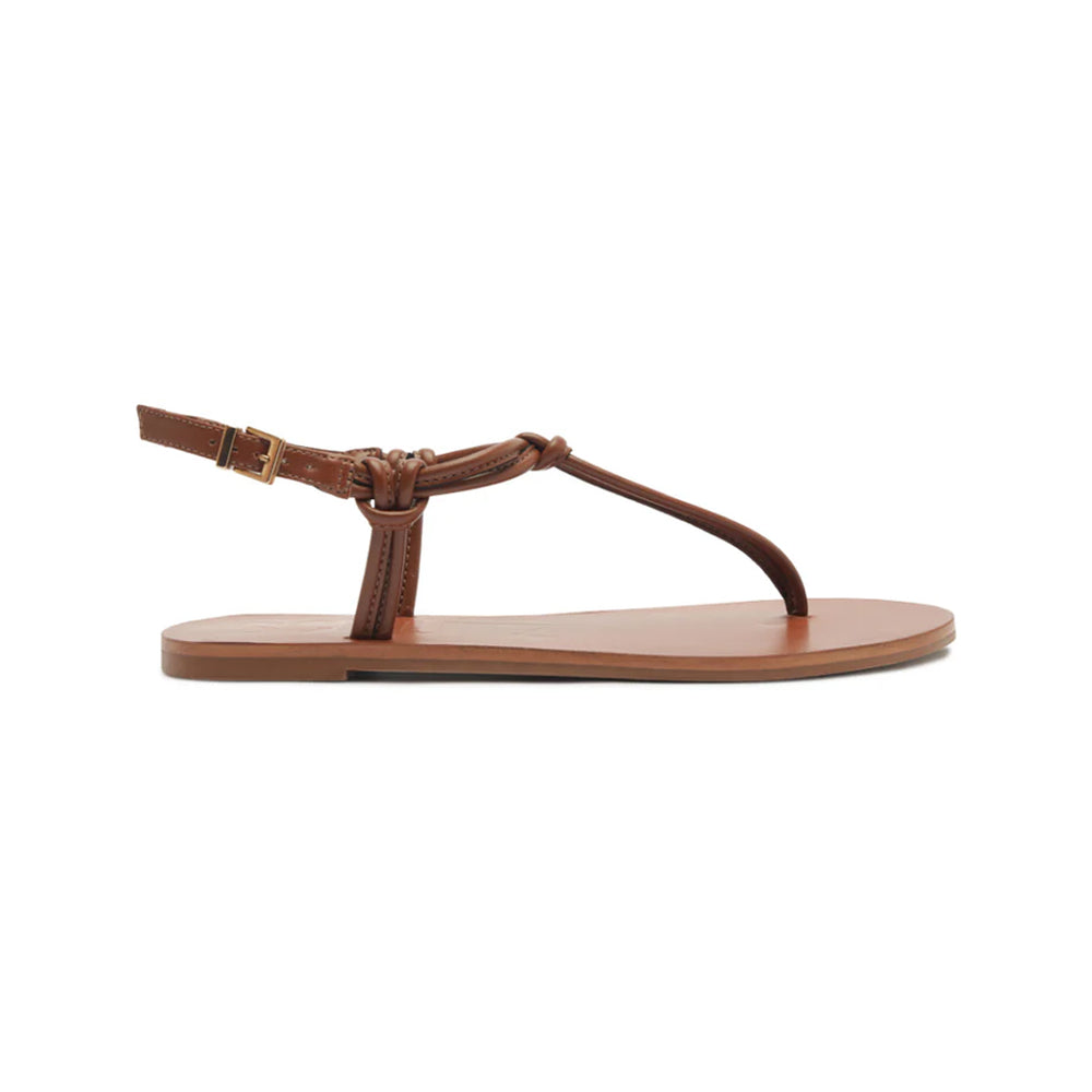 Side view of Nina sandal in cognac showcasing thong-style leather upper and adjustable ankle buckle on white background