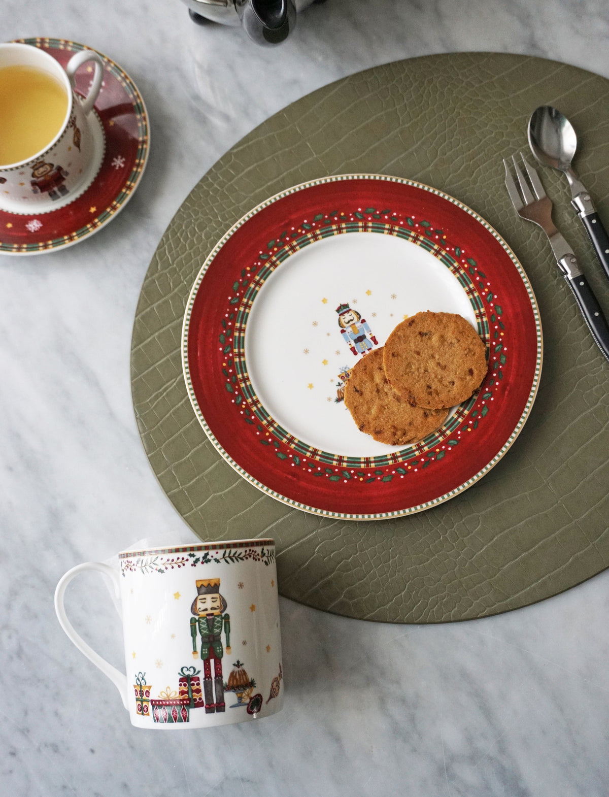 Overhead view of Nutcracker Salad and Dessert Plate showcasing its red holiday border and nutcracker design with cookies on a table