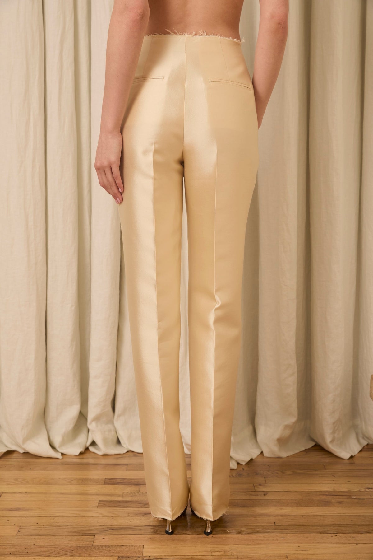 Rear view of Ophelia slim-leg pant in champagne silk-wool showing high waist, pressed crease and welt back pockets