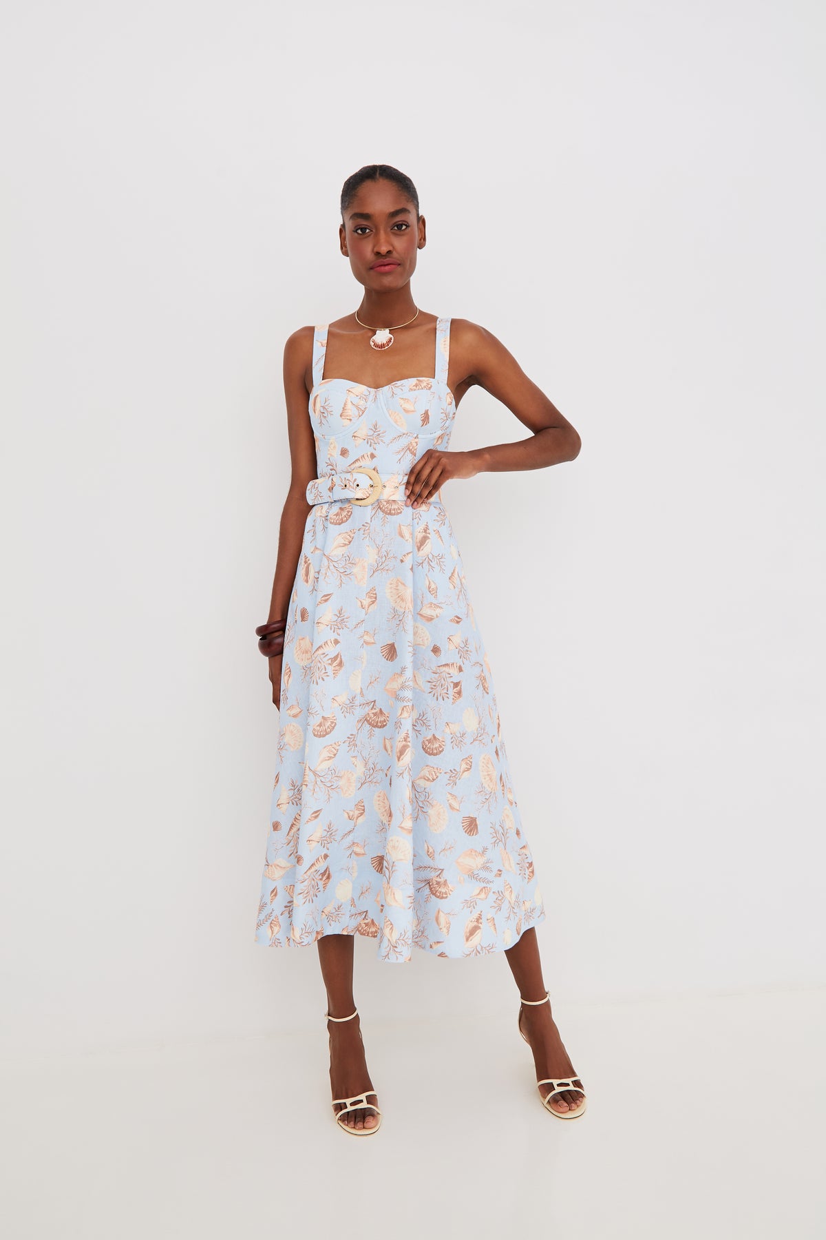Front view of Calypso dress in Seashell Sky with sweetheart neckline, wide straps, belted waist, and midi A-line skirt on white