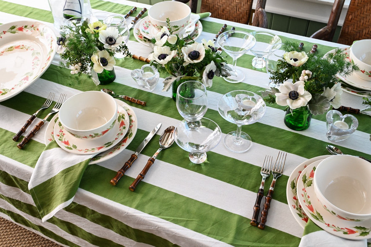 Three-quarter view of Ascutney Martini glass showing its balanced stem and rounded bowl on a green-and-white striped table setting