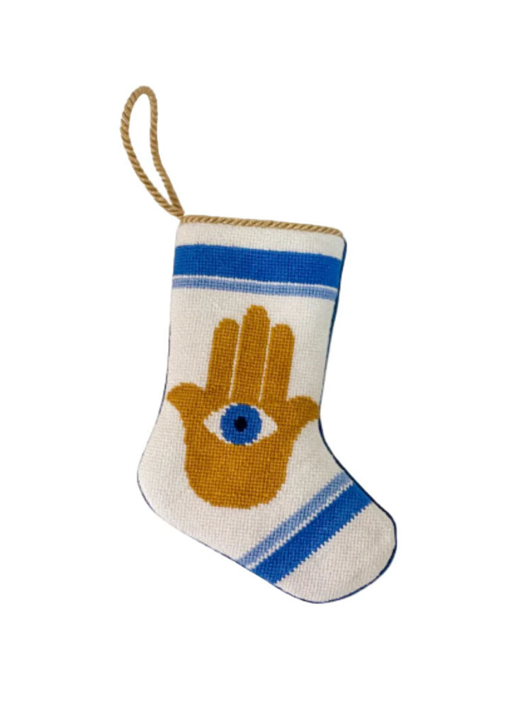 Front view of Hamsa bauble stocking showcasing needlepoint Hamsa motif, blue stripes and gold hanging loop on white background