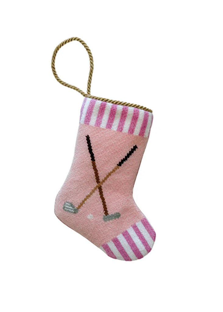 Front view of Tee Time Tidings pink bauble stocking showcasing crossed golf-club needlepoint, striped cuff, and gold hanging loop on white background