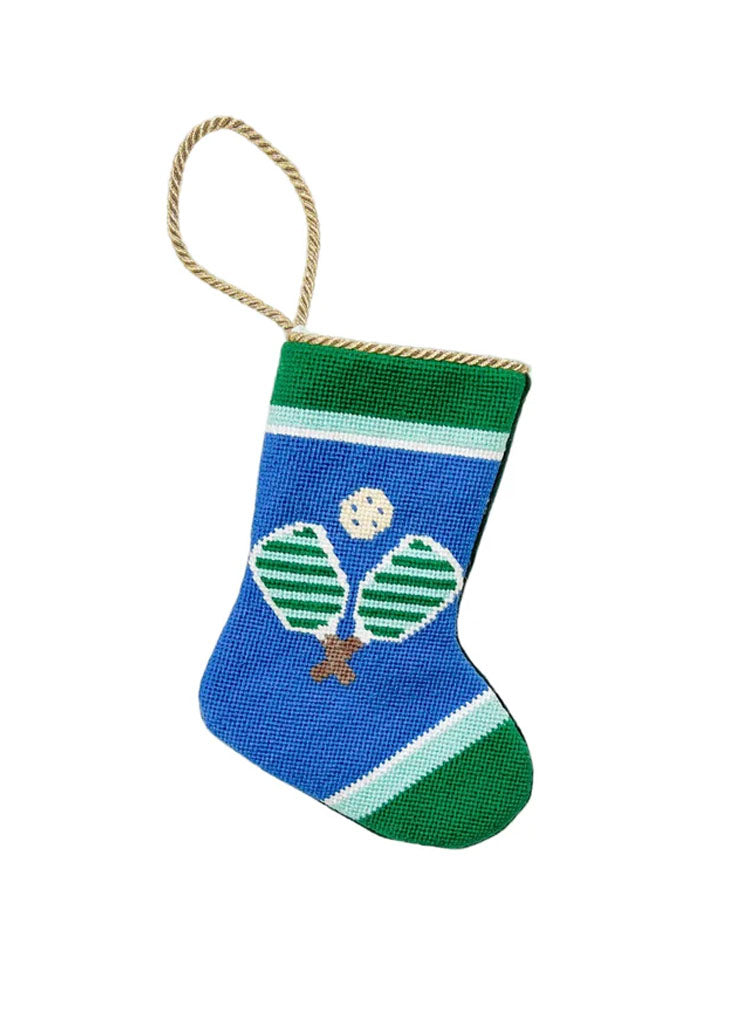 Front view of Pickle Palooza stocking showing two striped pickleball paddles and ball on blue with green trim and gold loop