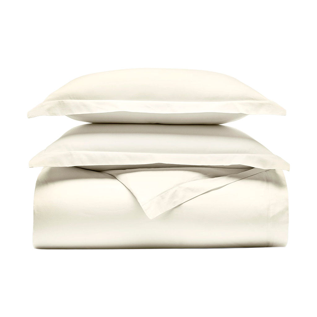 Front view of Percale Hemmed Duvet Set in Cream showcasing layered bedding and hemmed edges with a white background