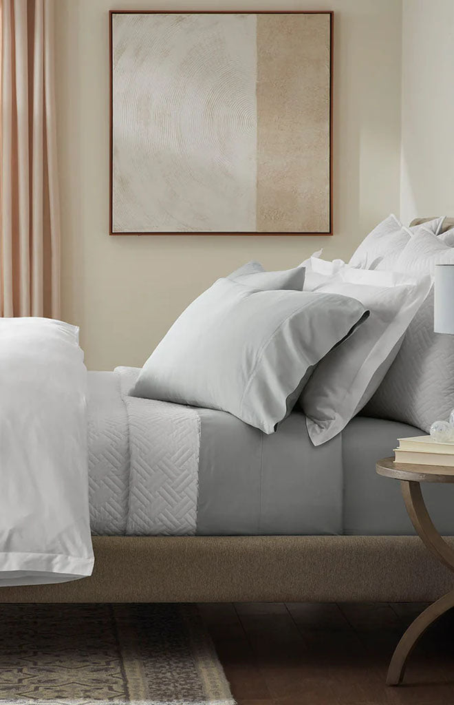Angled view of Percale Hemmed Sheet Set in Shore showing hemmed edge and percale texture on a styled bed