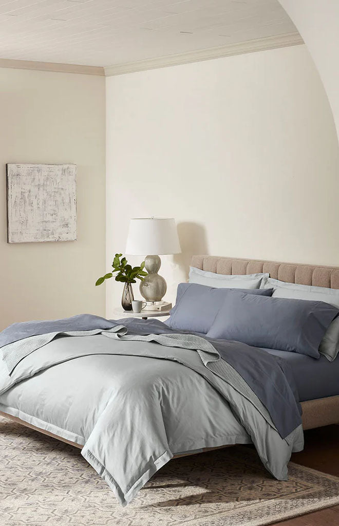 Angled view of Percale Hemmed Sheet Set in Mineral showcasing hemmed edges and smooth percale finish on a styled bed in a neutral bedroom